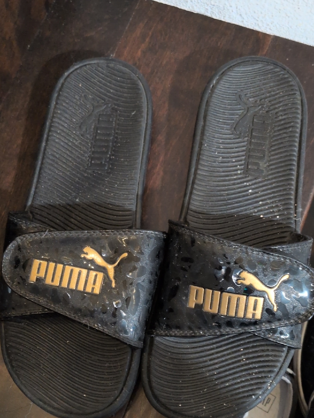 Puma Black Slides with Gold Logo Accent